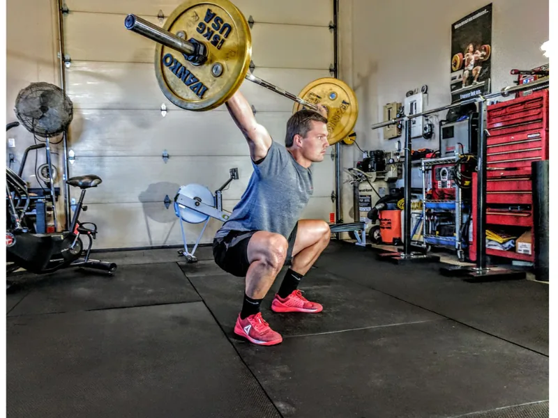 An athlete performing a loaded barbell squat