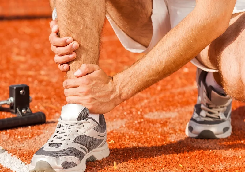 A clinician working on an athlete&rsquo;s knee during rehab