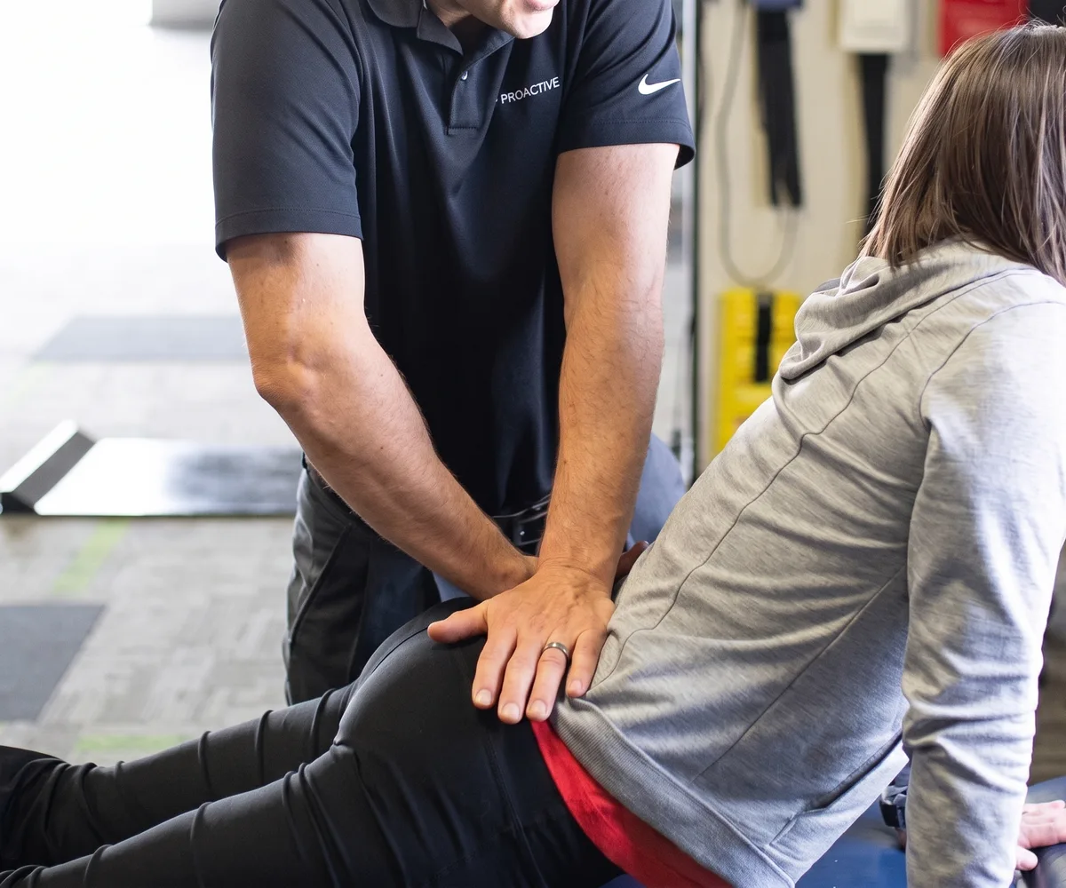 A physical therapist guiding a patient through a shoulder movement