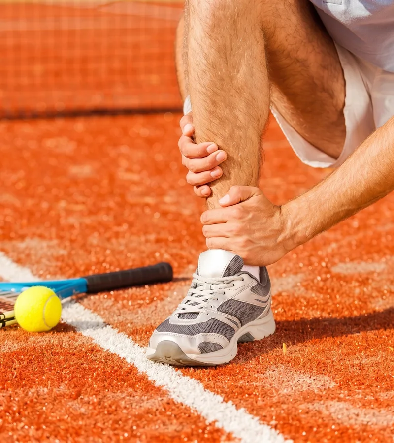 A clinician working on an athlete&rsquo;s knee during rehab